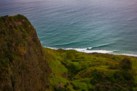 Narrow promontory rising high above over calm blue waters of Tasman Sea. Te Toto Gorge Lookout, Raglan, New Zealandの写真素材