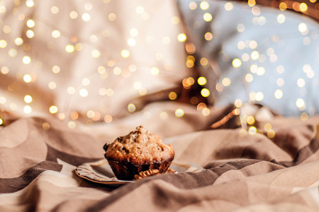Delicious fresh cupcake with nut on a plate in bed.  Morning  muffins with Raisins Copy spaceの写真素材