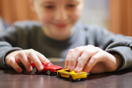 Happy child 6-8 years playing with cars and toys at home, indoor.の写真素材