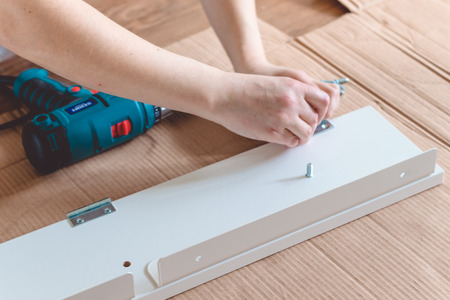 Furniture assembling using battery drill Close-up of the process of installationの写真素材