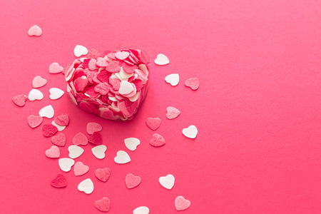 Box filled with many pink little hearts. Composition for a card with a place for textの写真素材