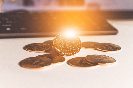 Shiny gold bitcoin coins scattered on wooden table, virtual moneyの写真素材