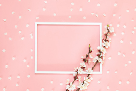 Flowers composition creative. Blank photo frame, pink flowers on living coral background, Copy space.の写真素材