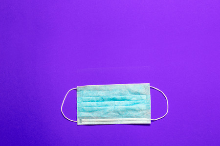 Medical face mask on purple background with copy spaceの写真素材