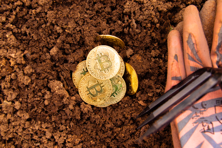 Bitcoin in the ground. Mining Golden Bitcoins conceptの写真素材