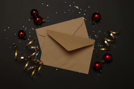 Craft envelopes decoration sparkles on a dark background with place for text. Top view, flat lay.