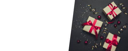 Christmas craft gifts with red ribbons and gold confetti on a dark contrast background