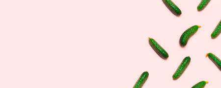 Fresh cucumbers on a pink background. Flat lay, top viewの写真素材