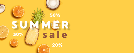 Creative summer composition of tropical fruit juices on a yellow background: oranges, coconuts, lemons, pineapples.の写真素材