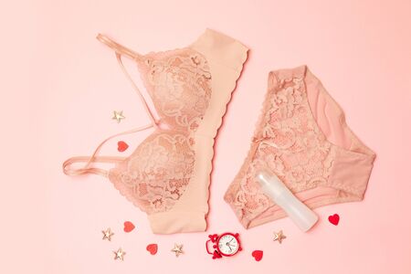 Valentines day concept. Womens underwear with accessories, watches and perfume on a pink backgroundの写真素材