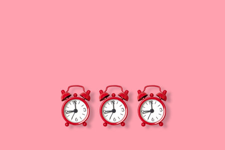 Flat lay retro beautiful red alarm clock on a pink background. Copy space