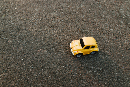 Odessa, Ukraine April 7 2019: Yellow toy car on the beach in the sunlight in summer. Vacation and travel concept. Sunrise on tropical island beach and car miniatureのeditorial素材