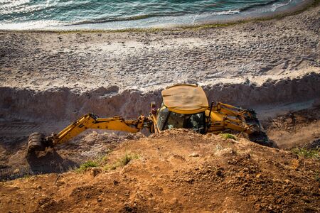 Tractor on a sandy beach, cleaning, after the winter, preparation for the holiday season.の写真素材