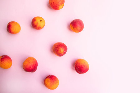 Flat composition of sweet juicy peaches on pink background