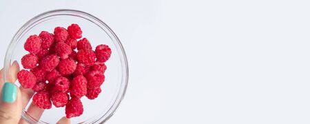 Fresh raspberries in a glass bowl and natural yogurt on a white table. Healthy eating conceptの写真素材
