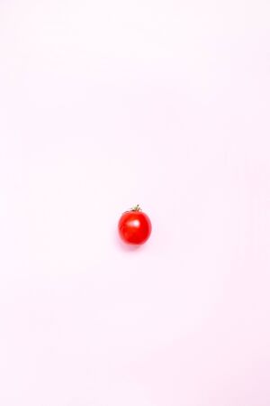 Red ripe tomato on a pink background. Flat lay. Food concept.の写真素材