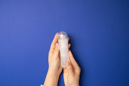 Health concept. Intimate lubricant in a female hand on a blue background