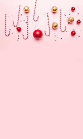 Creavive Christmas Background with Candy Canes, gold and red balls on pink background. Template mockup greeting card text designの写真素材