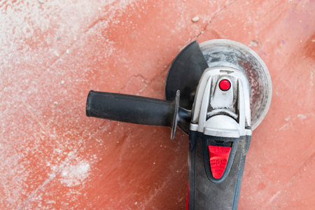 Top view of electric angle grinder on a wooden floor. Home repair concept