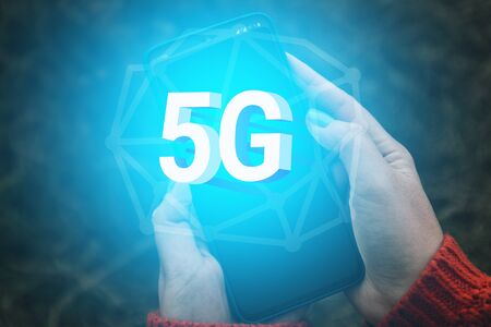 5G network wireless systems and internet concept. The human hand holds a smartphone and uses a high-speed Internet data networkの写真素材