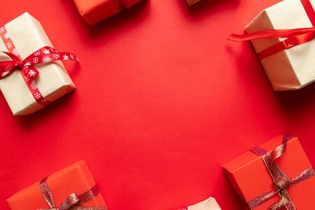 Christmas craft handmade gift boxes on red background top view. Holidays greeting card, frame, banner.の写真素材