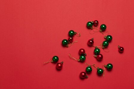 Trendy christmas multicolored classic christmas little balls on red background. Flat lay, top viewの写真素材