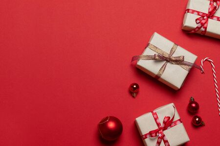 Christmas and New Year holiday banner with surprise craft boxes, red tape bow and classic red glass baubles balls horizontal border.の写真素材