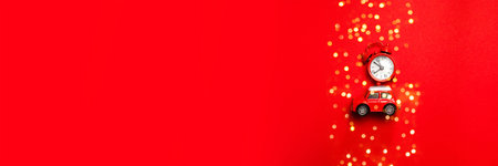 Little red toy car and red clock on a red background. Minimal design for celebrating christmas or...
