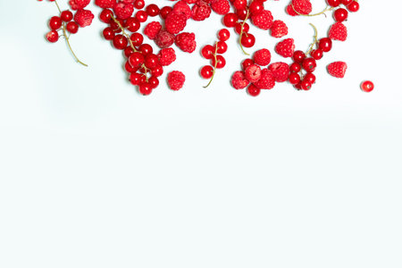 Top view and flat lay of fresh juicy raspberry berries on a blue background with copyspace