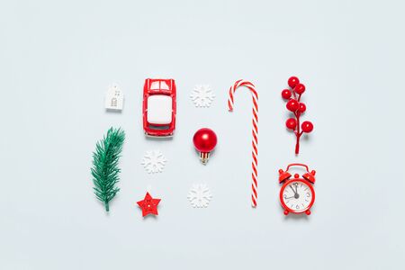 Flat lay of decor frame with Christmas tree branch, clock, twig with berries, toy car, candy cane on blue background. New Year. Flat lay creative idea designの写真素材
