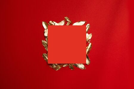 Creative composition with red leaf frame with gold leaves on a red background, minimal style template.の写真素材