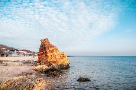 Sharp big red stones near the shore of the Black Sea with blue clouds sky. Amazing seascapeの写真素材