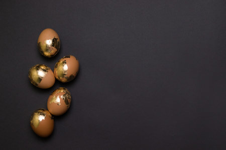 Happy easter concept. Gold decor chicken egg on black background. Top view, flat lay. Happy easter