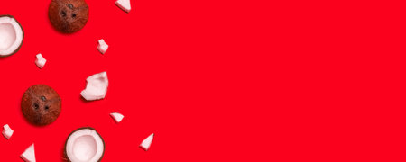 Assorted pieces of coconut, walnut halves on a red background with copy space