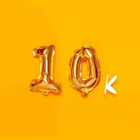 10,000 gold sign balloon on a yellow background. Subscribe concept. Holiday poster for banner, posterの写真素材