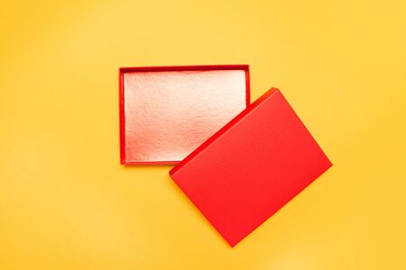 Open red box with a lid on a yellow background, top view, flat lay. Mock up or template design.の写真素材
