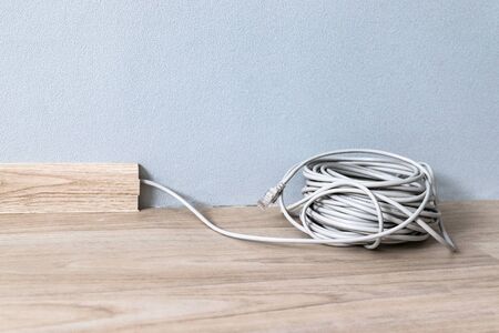 Internet web cable RJ 45 in the baseboard along the gray wall in the room.の写真素材