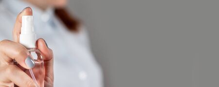 Female hand holds a sanitizer gel plastic bottle for protection against coronavirus, banter on handの写真素材