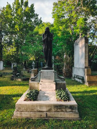 Old grave with a monument to a famous person in the cemetery. Architectural stone statue,old historic grave and funeral monument in Budapest, Hungary.の写真素材