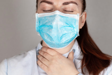 Young girl in a medical mask feels bad. Sore throat, illness. Coronavirus, covid 19