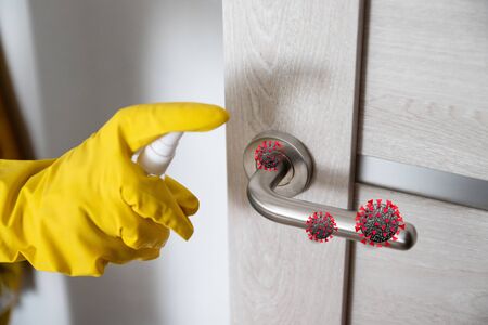 Coronavirus, covid 19 protection. Hand disinfects and cleans door handle with antibacterial wet wipes to protect against viruses, germs and bacteria during coronavirusの写真素材