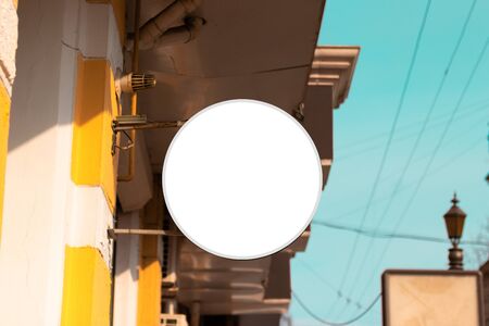 Modern white iron hollow round signboard. Mock up signboard on the building on the streetの写真素材