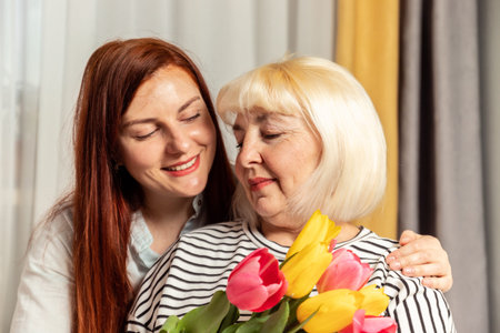 Mother and young daughter are hugging. Happy loving family. 50 years old blonde mature woman holding...