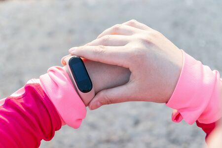 Woman using fitness tracker or heart rate monitor after training outdoors.の写真素材