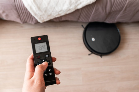 The robot vacuum cleaner removes dusty floor cleaning in the bedroom using the remote control. Smart...