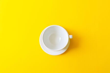 Concept morning breakfast, drink coffee or tea.Top view of an empty white ceramic cup on a yellow backgroundの写真素材