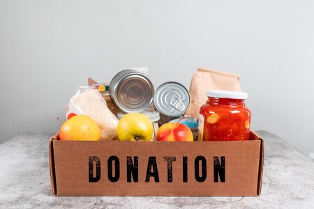 Various canned food, pasta and cereals in a cardboard box. food donations or food delivery concept.の写真素材