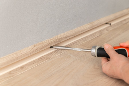 Man work on the installation of plastic plinth on grey wall. Close up.の写真素材