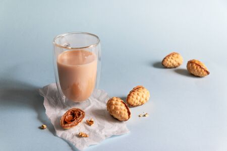 Hot coffee with milk and cookies on a blue background with copy spaceの写真素材