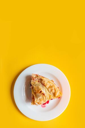 Top view of a piece of delicious homemade cherry pie on a yellow background with copy space. Vertical photoの写真素材